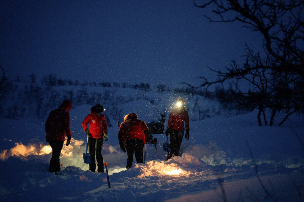 The team digging out spaces for their tents in the dark on Day 2. (Photo by Brodie Hood/Comic Relief)