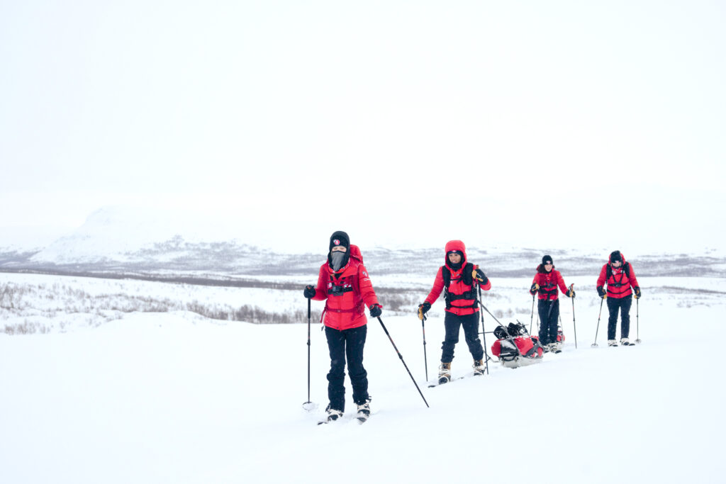 The team trekking through brutal Arctic winds on Day 3.  (Photo by Brodie Hood/Comic Relief)